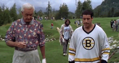 A Man In A Boston Bruins Jersey Is Standing On A Golf Course Next To A Man In A Floral Shirt . GIF