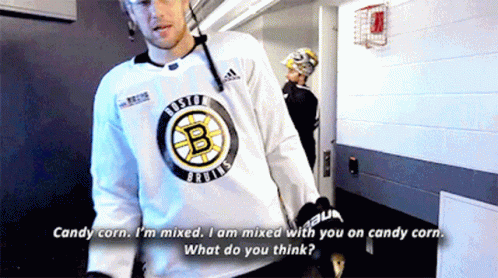 A Man In A Boston Bruins Jersey Talks To Another Man GIF