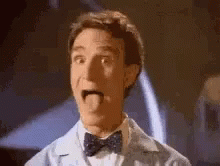 A Man In A Bow Tie Is Sticking His Tongue Out And Making A Funny Face . GIF