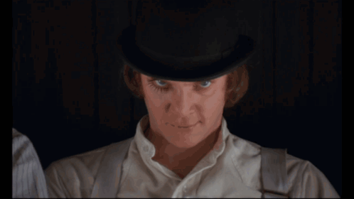 A Man In A Bowler Hat Drinks Milk From A Glass GIF