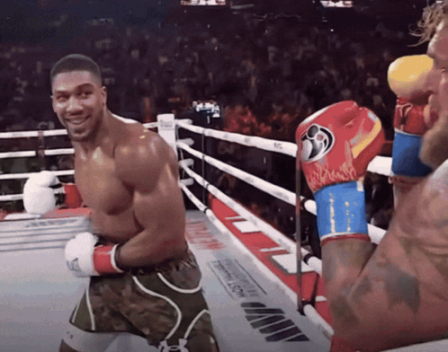 A Man In A Boxing Ring Wearing A Pair Of Boxing Gloves With A Flame Pattern GIF