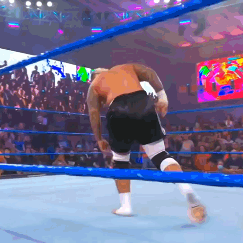 A Man In A Boxing Ring With A Crowd Behind Him GIF