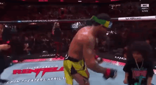 A Man In A Boxing Ring With A Sign That Says ' Rent ' On It GIF