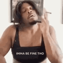 A Man In A Bra Is Smoking A Cigarette While Wearing A Wig . GIF