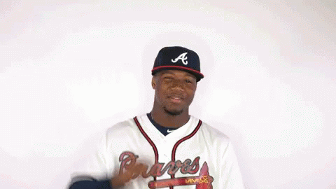 A Man In A Braves Jersey Flexes His Muscles GIF
