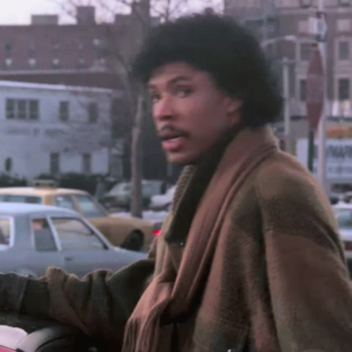 Man In Brown Coat In Front Of City Street GIF