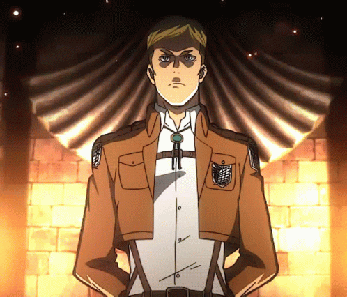 A Man In A Brown Jacket And White Shirt Stands With His Hands On His Hips In Front Of A Brick Wall GIF