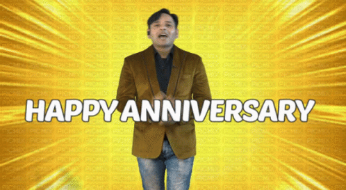 A Man In A Brown Jacket Stands In Front Of A Yellow Background That Says Happy Anniversary GIF