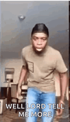 A Man In A Brown Shirt And Blue Jeans Is Standing In A Living Room . GIF