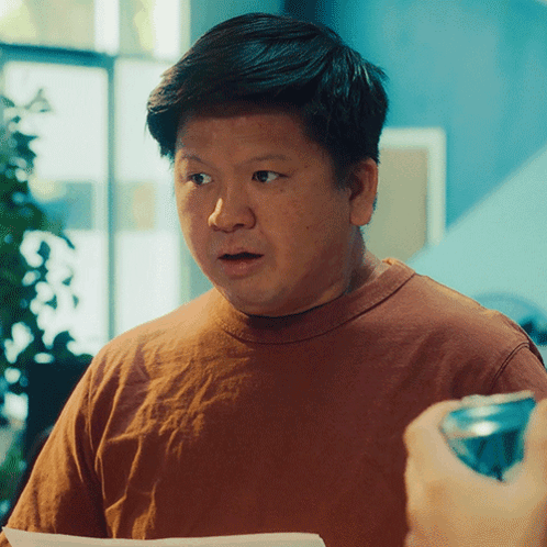 A Man In A Brown Shirt Looks Surprised While Holding A Can Of Soda GIF