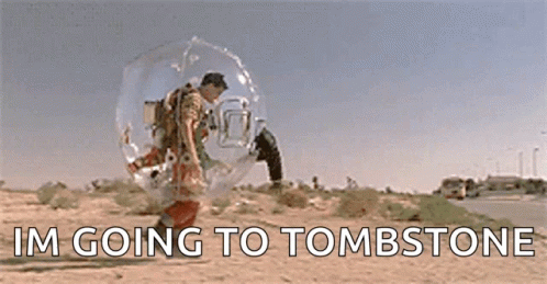 A Man In A Bubble Is Walking Down A Desert Road . GIF