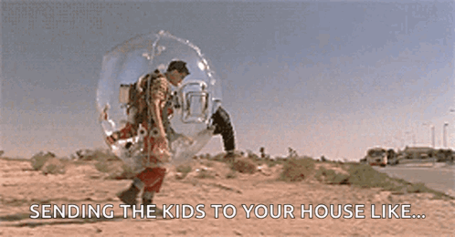 A Man In A Bubble Is Walking Down The Street . GIF
