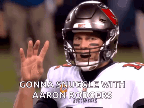 A Man In A Buccaneers Jersey Is Waving His Hand GIF