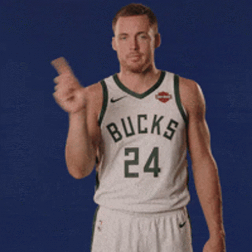 A Man In A Bucks Jersey Is Holding Something GIF