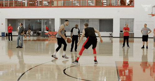 A Man In A Bulls T-Shirt Is Playing Basketball GIF