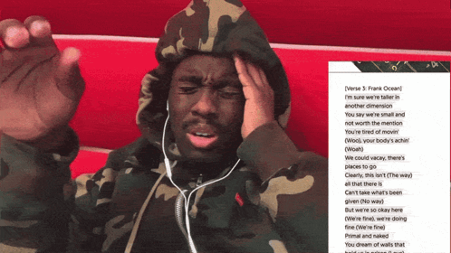 A Man In A Camo Hoodie Is Listening To Music GIF