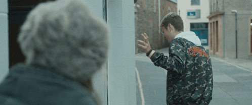 A Man In A Camo Jacket Is Standing Next To A Woman GIF