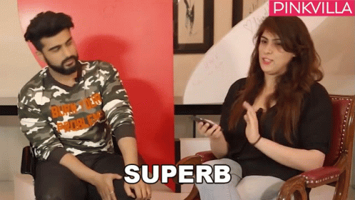 A Man In A Camo Shirt Sits Next To A Woman In A Black Shirt With The Word Superb On It GIF