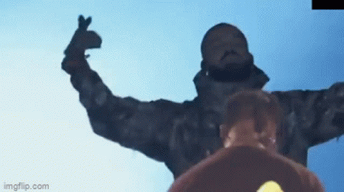 A Man In A Camouflage Jacket Is Making A Heart Shape With His Hands GIF