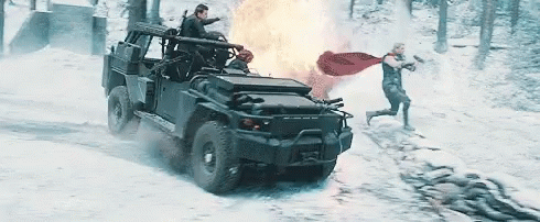 A Man In A Cape Is Running Towards A Military Vehicle GIF