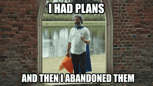 A Man In A Cape Is Standing In Front Of A Brick Wall With The Caption I Had Plans GIF