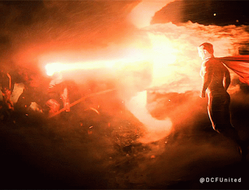 A Man In A Cape Is Standing In Front Of A Fire With The Hashtag @Dcfunited GIF