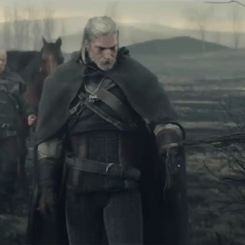 a man in a cape is standing next to a horse