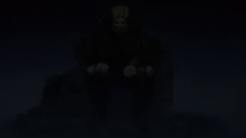 A Man In A Cape Sits On A Throne With His Hands In His Pockets GIF