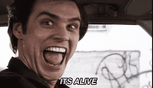 A Man In A Car With His Mouth Open And The Words It 'S Alive On The Bottom GIF