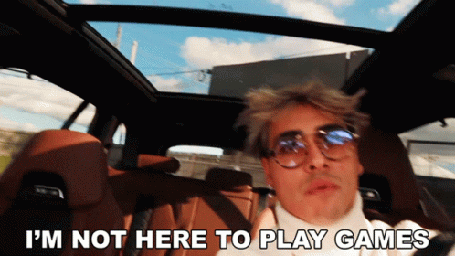 A Man In A Car With The Words " I 'M Not Here To Play Games " Below Him GIF