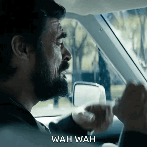 A Man In A Car With Wah Wah Written On The Bottom Right GIF
