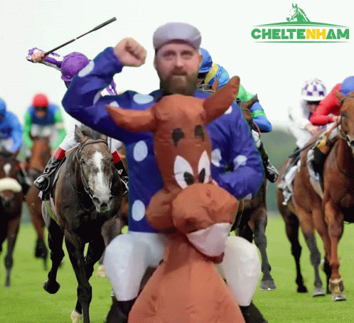 A Man In A Cartoon Horse Costume Rides A Horse In A Race GIF