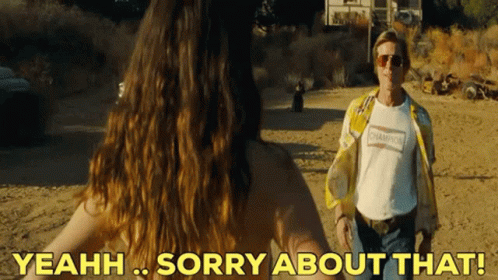 A Man In A Champion Shirt Stands Next To A Naked Woman In The Desert GIF