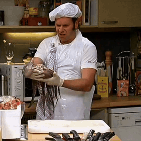 a man in a chef 's hat is holding a large octopus in his hands
