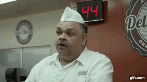 A Man In A Chef 'S Hat Stands In Front Of A Digital Clock That Says 44 GIF