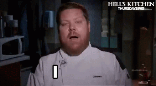 A Man In A Chef 'S Uniform Is Making A Funny Face While Standing In A Kitchen . GIF