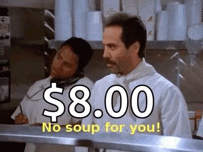 A Man In A Chef 'S Uniform Is Standing In A Kitchen Talking On A Phone While Another Man Looks On . GIF
