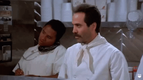A Man In A Chef 'S Uniform Is Talking On A Cell Phone GIF
