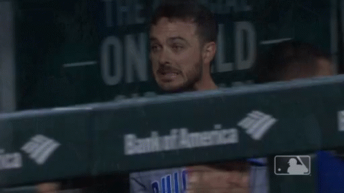 A Man In A Chicago Baseball Uniform Stands In A Dugout GIF
