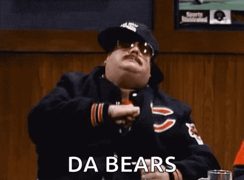 A Man In A Chicago Bears Jacket Is Sitting At A Table In A Bar With His Arms In The Air . GIF