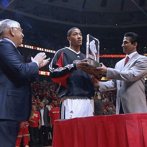 A Man In A Chicago Jersey Holds A Trophy GIF