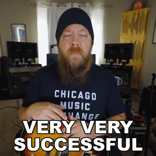 A Man In A Chicago Music Change Shirt Is Holding A Guitar GIF