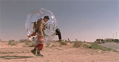 A Man In A Clear Bubble Walking Down A Street GIF