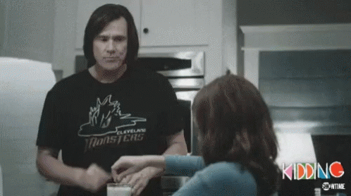 A Man In A Cleveland Monsters T-Shirt Is Feeding A Woman A Glass Of Milk . GIF