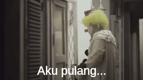 A Man In A Clown Costume Is Standing In Front Of A Door And Saying Aku Pulang . GIF