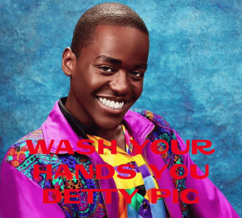 A Man In A Colorful Jacket Is Smiling With The Words " Wash Your Hands You Deity Pic " Behind Him GIF