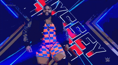 A Man In A Colorful Outfit Is Standing In Front Of A Sign That Says Wwe . GIF