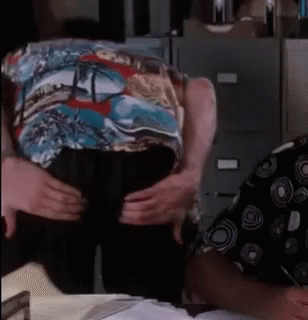 A Man In A Colorful Shirt Is Being Held By Another Man GIF