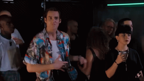 A Man In A Colorful Shirt Is Dancing In A Crowd Of People GIF