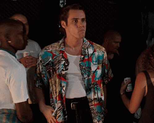 A Man In A Colorful Shirt Is Standing In A Crowd Of People GIF